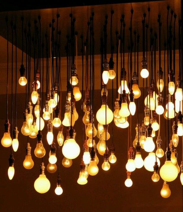 Bare light bulbs suspended from ceiling casting warm glow.