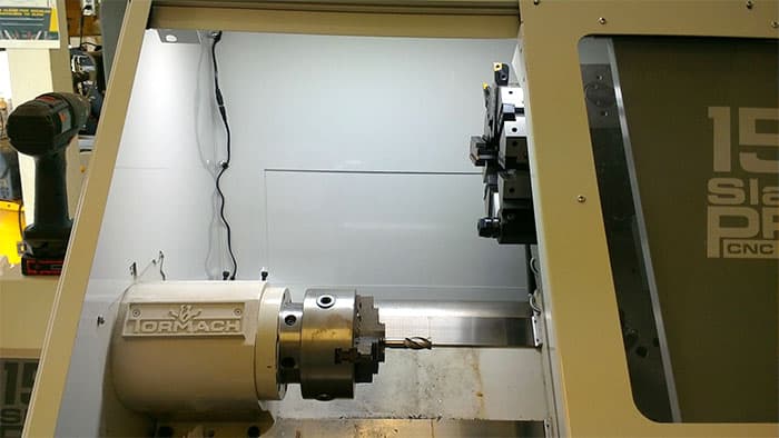 Machine shop lighting system with overhead and task lamps.