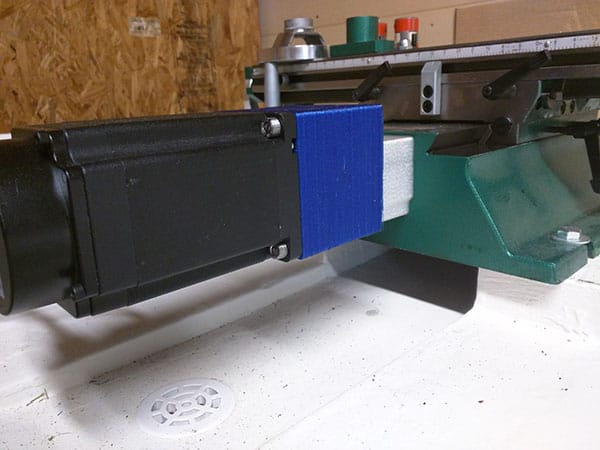 Black cylinder with blue square on white surface.