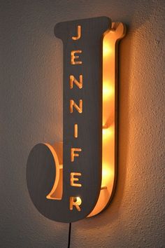 Large illuminated sign with text "Jennifer" on a modern, textured white background.