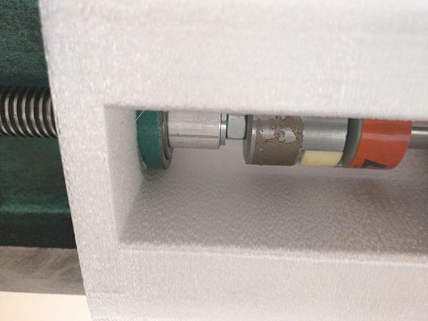 Metal object with cylindrical component in red and white.