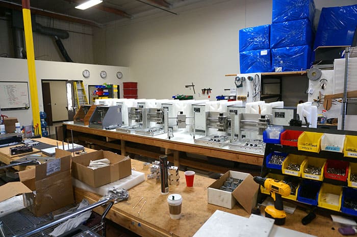 Cluttered workshop with drill press, milling machine, and metal lathe.