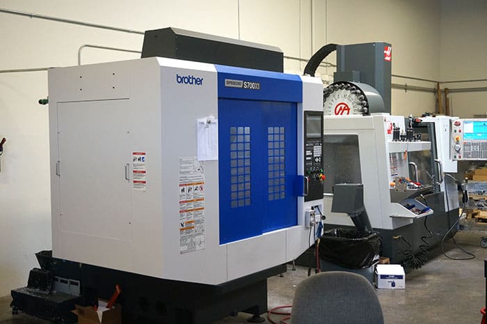 Brother S700II CNC milling machine in a well-lit metal fabrication shop.