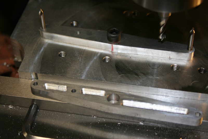 Metal beam with screws and bolts in a machine shop or manufacturing setting.