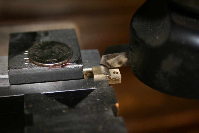 Metal beam clamp in machine shop setting.