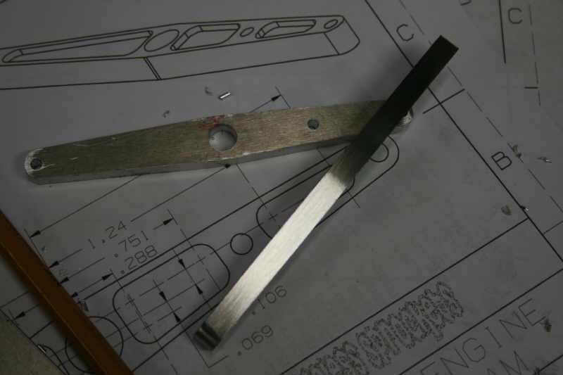 A beam caliper lying diagonally on top of an engineering drawing with one arm cut off.