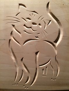 A stylized cat carved into wooden surface with curved lines and abstracted features, featuring subtle smile on face and simplified body emphasizing fluid motion.