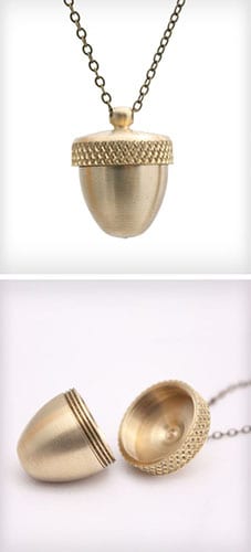 Gold-toned metal acorn-shaped locket on a chain, possibly brass or bronze.