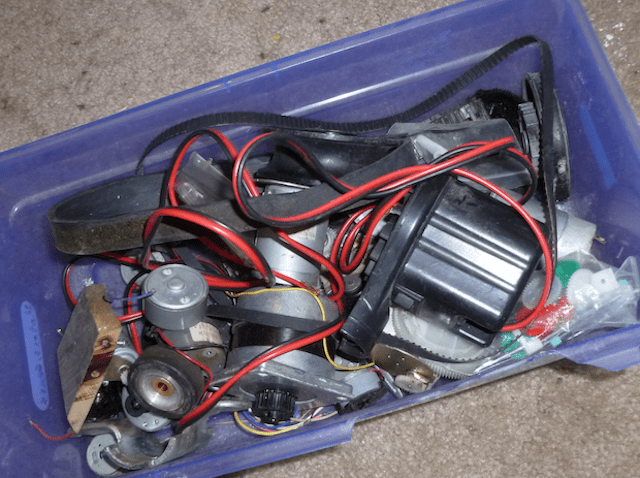 Machine shop junkyard with tangled wires and machinery parts.