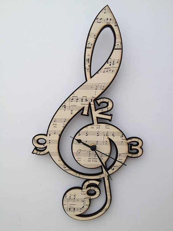 Treble clef-shaped clock with musical notes and sheet music.