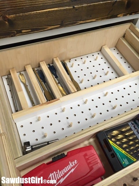 Wooden drawer with pegboard organizer and tools.