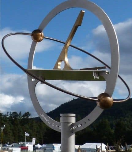 A sundial with complex geometric shapes in a natural setting.