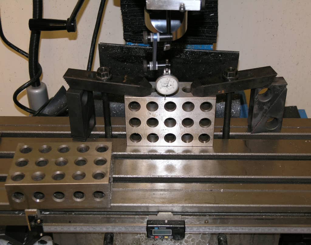 Metalwork machinery setup with drill press, milling machine, and other tools in a workshop or factory setting.
