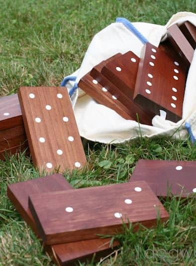 Oversized wooden dominoes on grassy surface.