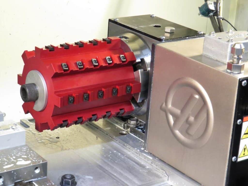 Red cylindrical object with gear-like design and metal shaft.