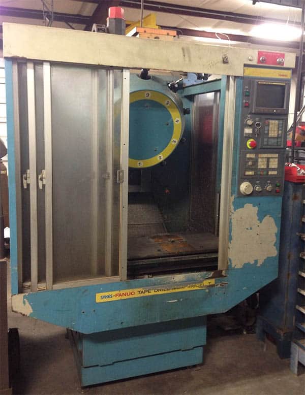 An old, worn-out metal fabrication machine with blue body and yellow accents.