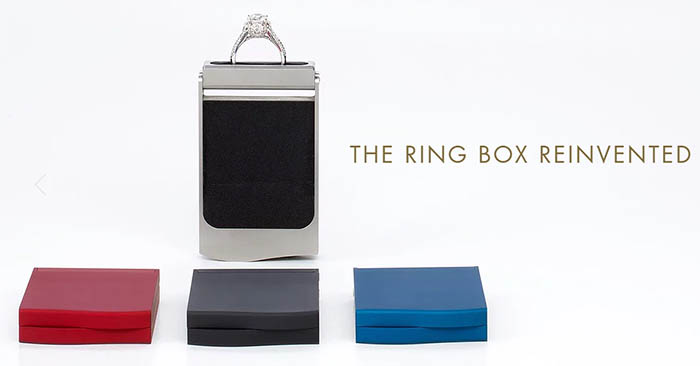 Silver Monarch Ring Box with diamond-encrusted handle on a white background surrounded by three smaller boxes in red, gray, and blue.