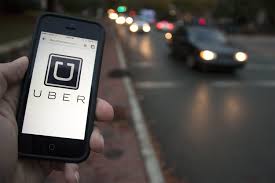 An iPhone showing the Uber app, with a blurred background of a car on a road.