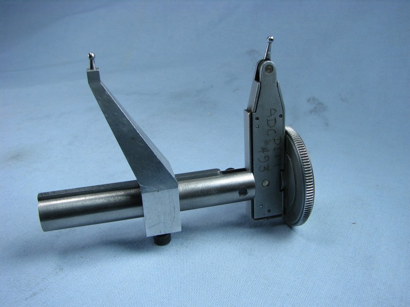 Dial indicator gage with rotating dial and needle measuring small distances or clearances.