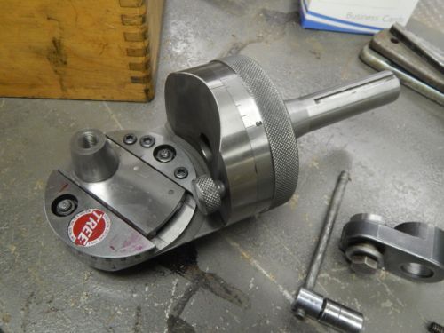 Automatic boring head with "TREE" engraved, resting on a metal surface.