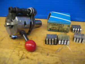 Geometric die head composed of various metal components on a flat surface.