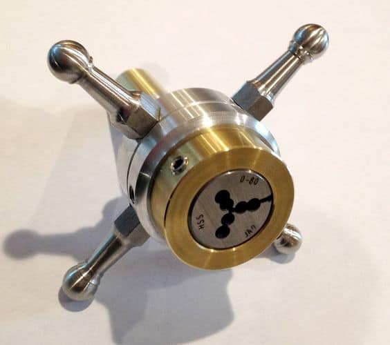 Metal die holder with cylindrical body and three protruding arms.