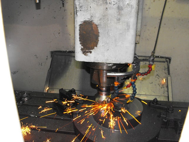 Metal object being welded in a machine shop workshop.