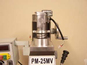 A cylindrical metal object with a black cord and flat base mounted on a stand.