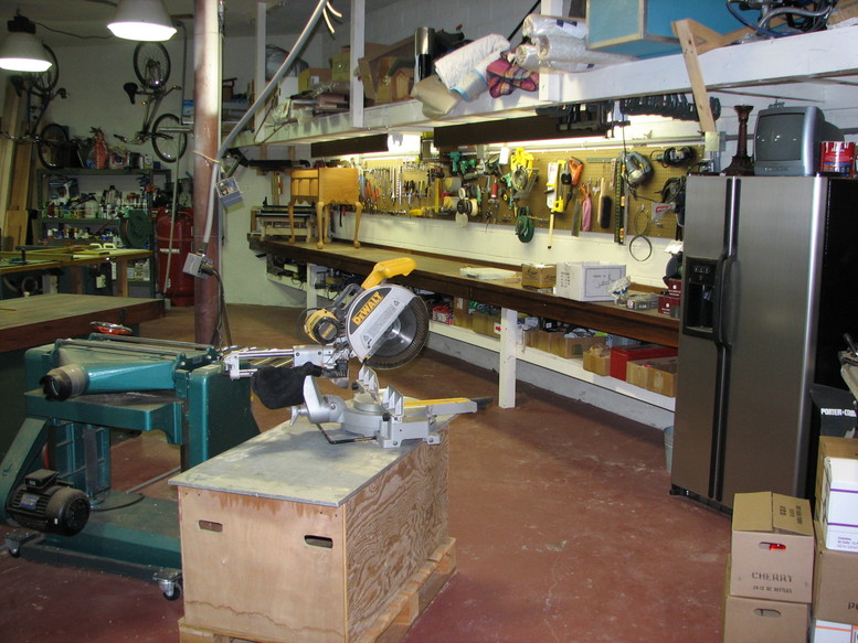 Cluttered workshop with tools and metalworking machinery.
