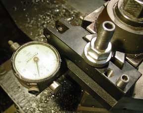 Pressure gauge attached to metal device with cylindrical connection.