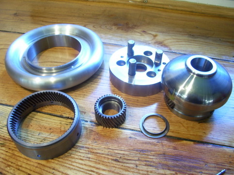 Silver metal parts on a wooden surface.