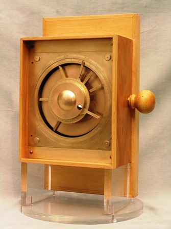 Antique wooden safe front panel with brass circular dial and keyhole.