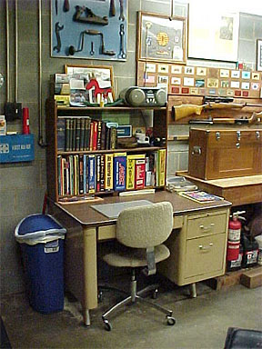 A cluttered workshop with tools and equipment on walls and floor.
