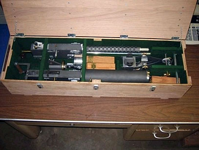 Mechanical components and tools in a wooden storage box.