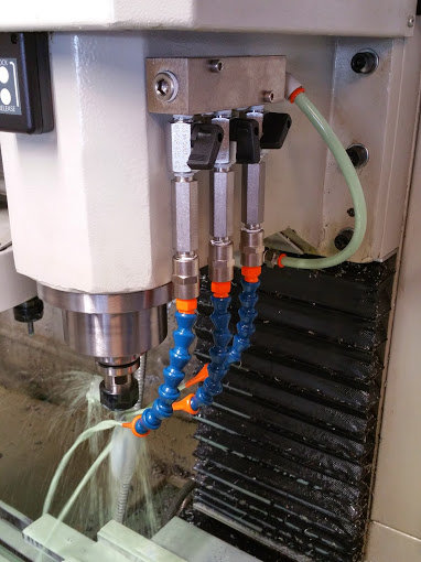 Coolant nozzles on a metalwork machine, showcasing intricate design.