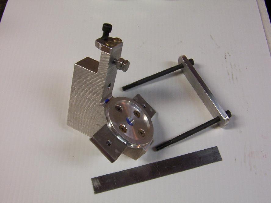 Precision metalworking tool set with threaded knob and various-sized holes.