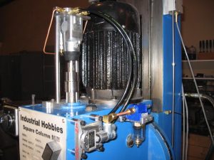 Blue industrial machine with black hose and label reading Industrial Mobbies.