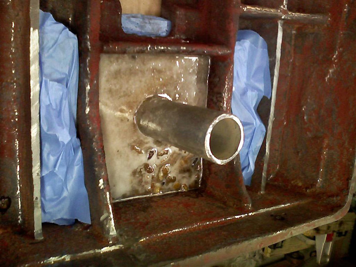 Metal object with cylindrical protrusion on dark background.