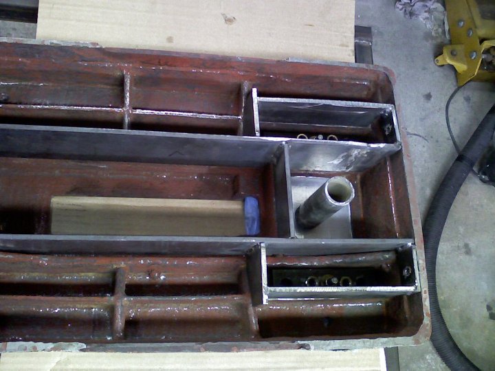 Metal parts on workbench, various shapes and sizes.