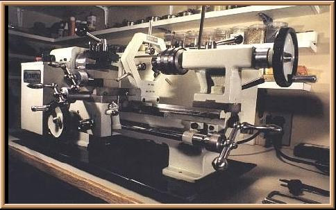 Large white lathe with black work surface, spindle, tailstock, and tool posts.