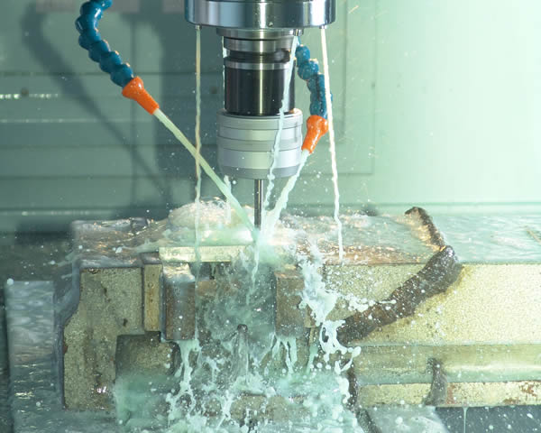 Industrial drilling machine submerged in water with blue and orange hoses.
