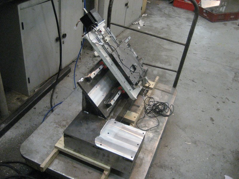 Metalworking setup with machinery and equipment on a workbench or table in a workshop or factory environment.