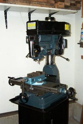 Large blue milling machine with yellow label and wooden beam background.