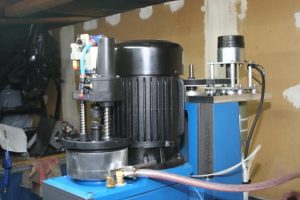 Industrial machine with black cylindrical body and blue base.