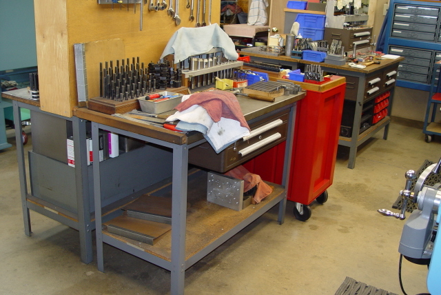 Well-organized woodworking shop with drill press, table saw, and workbench.