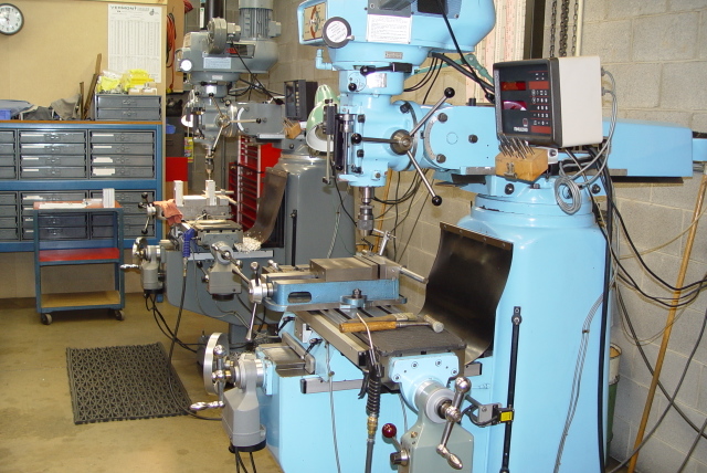 Blue machinery collection in a workshop setting with digital displays, spindles, motors, and control panels.