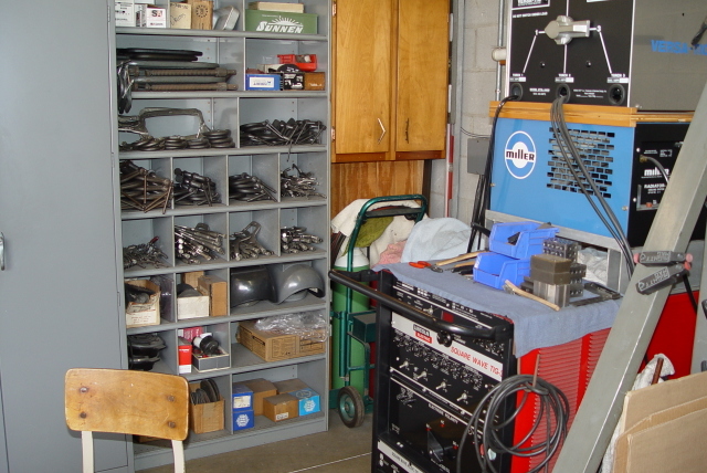 Well-organized workshop with miller welding cart and metalworking tools.