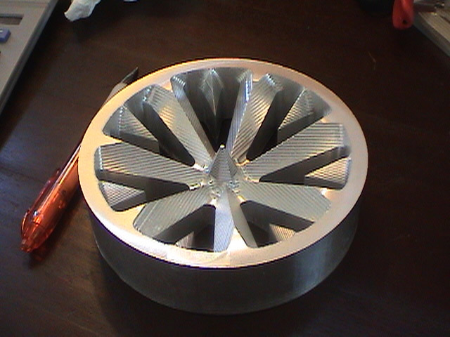 Metal object with starburst pattern on surface.