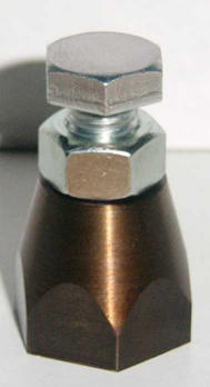 Metal screw or bolt head with hexagonal recess and elongated cone-shaped base.