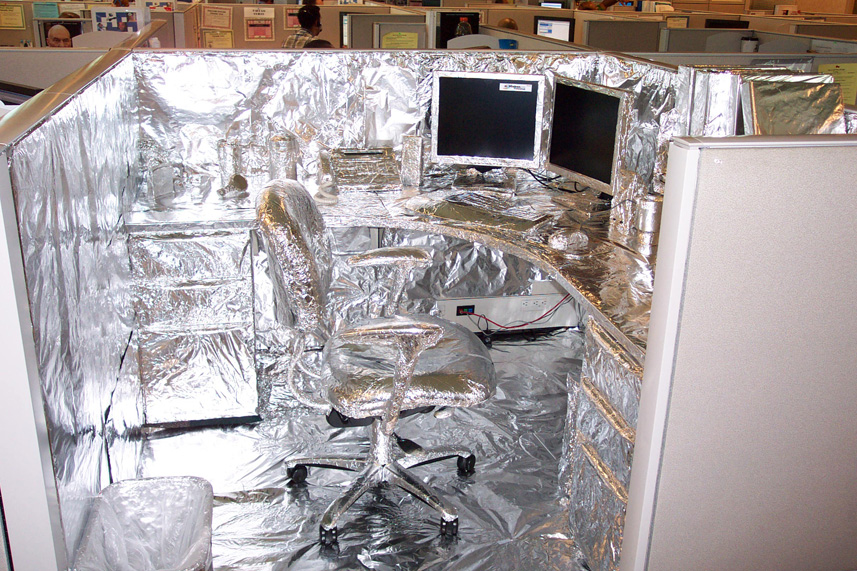 A cubicle covered in aluminum foil.